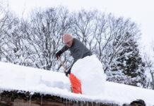 Cómo un hombre limpia el techo del segundo piso cubierto de nieve